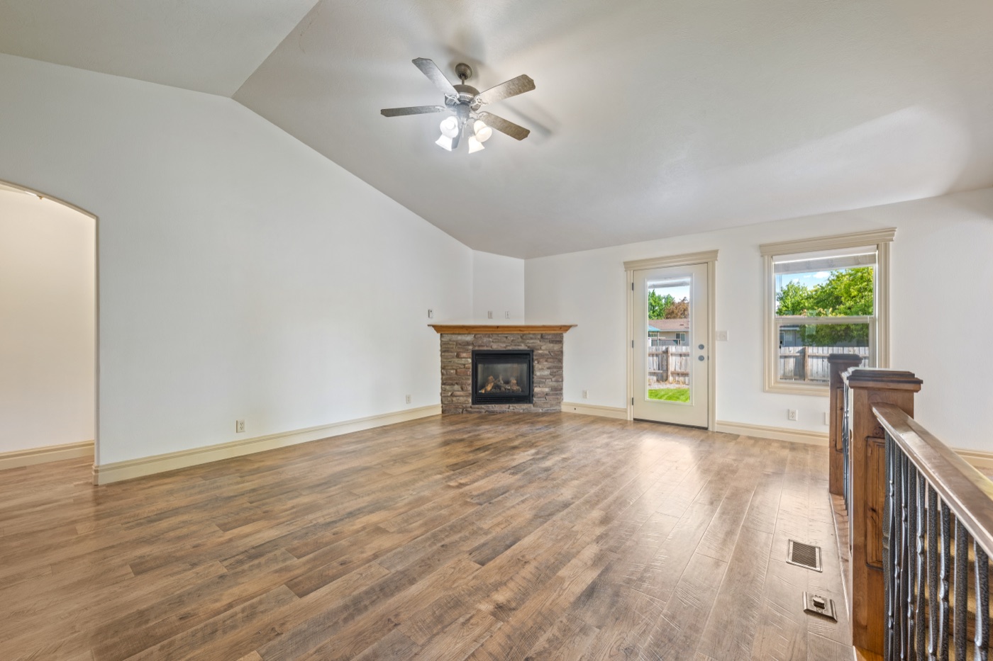Living room with stone fireplace and vaulted ceiling