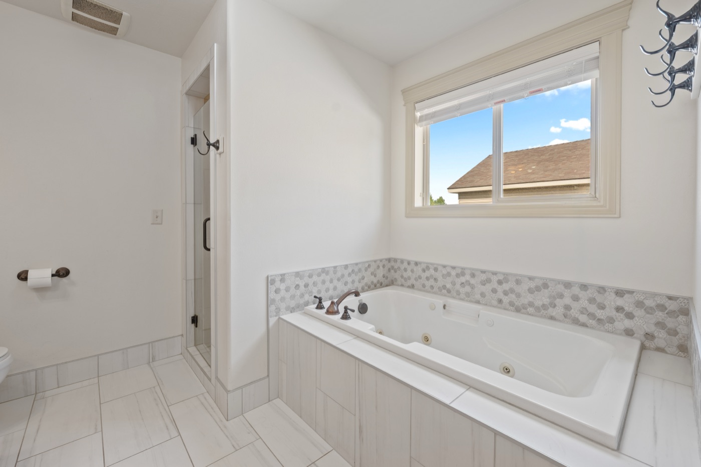 Reimagined primary bathroom with jetted tub and frameless shower